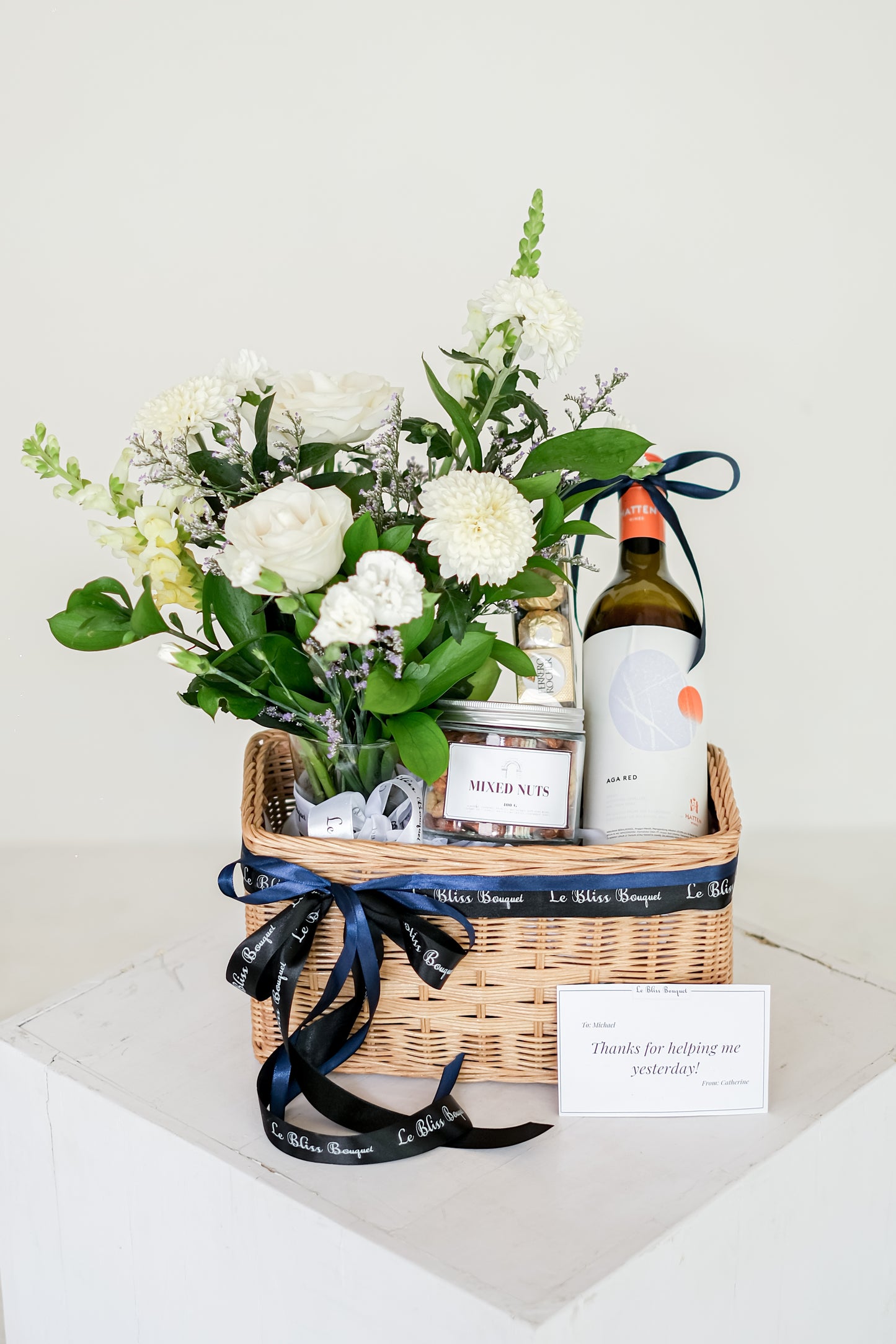 wine hamper surabaya, parcel wine hamper jakarta by le bliss. hate wine, mixed nuts, Ferrero, and fresh flowers in vase