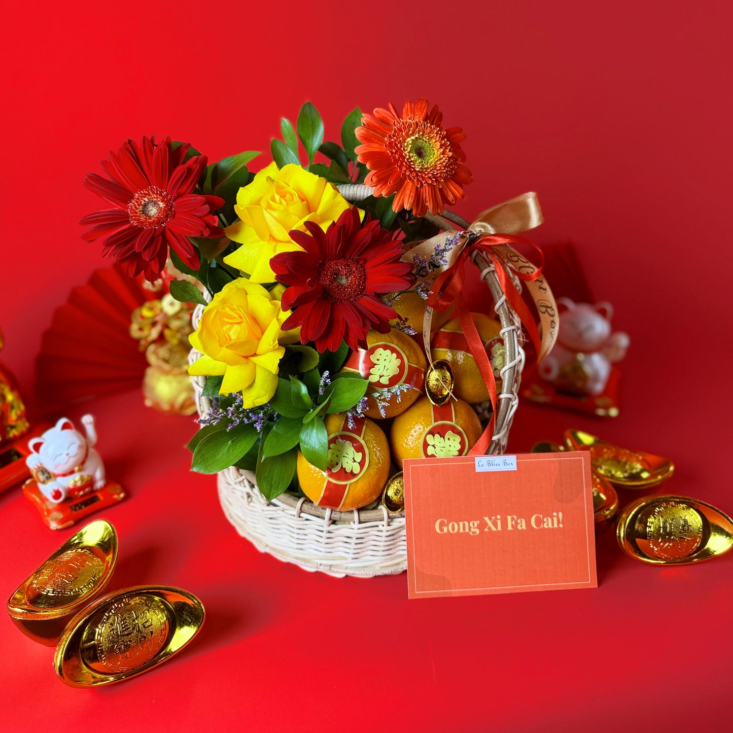 Floral arrangement in a basket with 'Gong Xi Fa Cai' card on a red background
