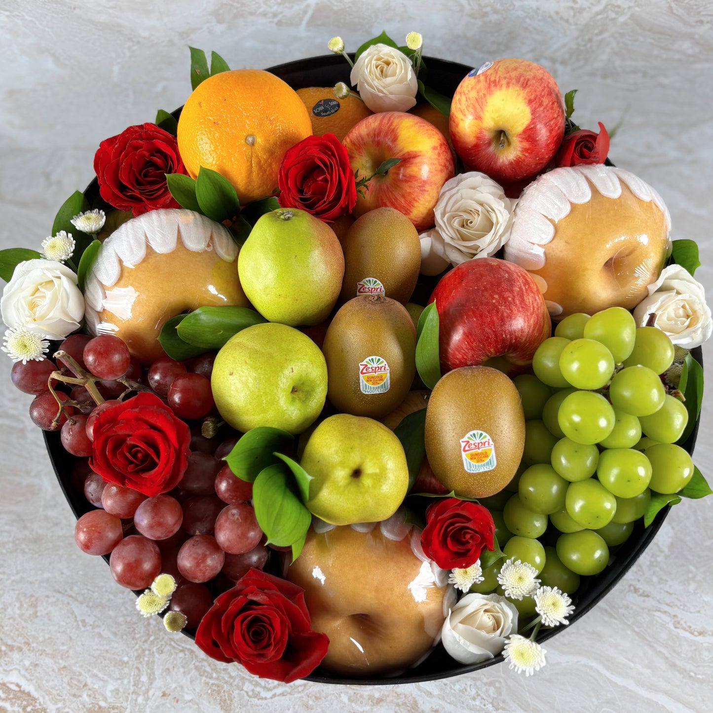 Fruit and flower arrangement in a black box labeled 'Le Bliss Box' on a light background. parcel buah, christmas hamper surabaya, christmas hamper jakarta