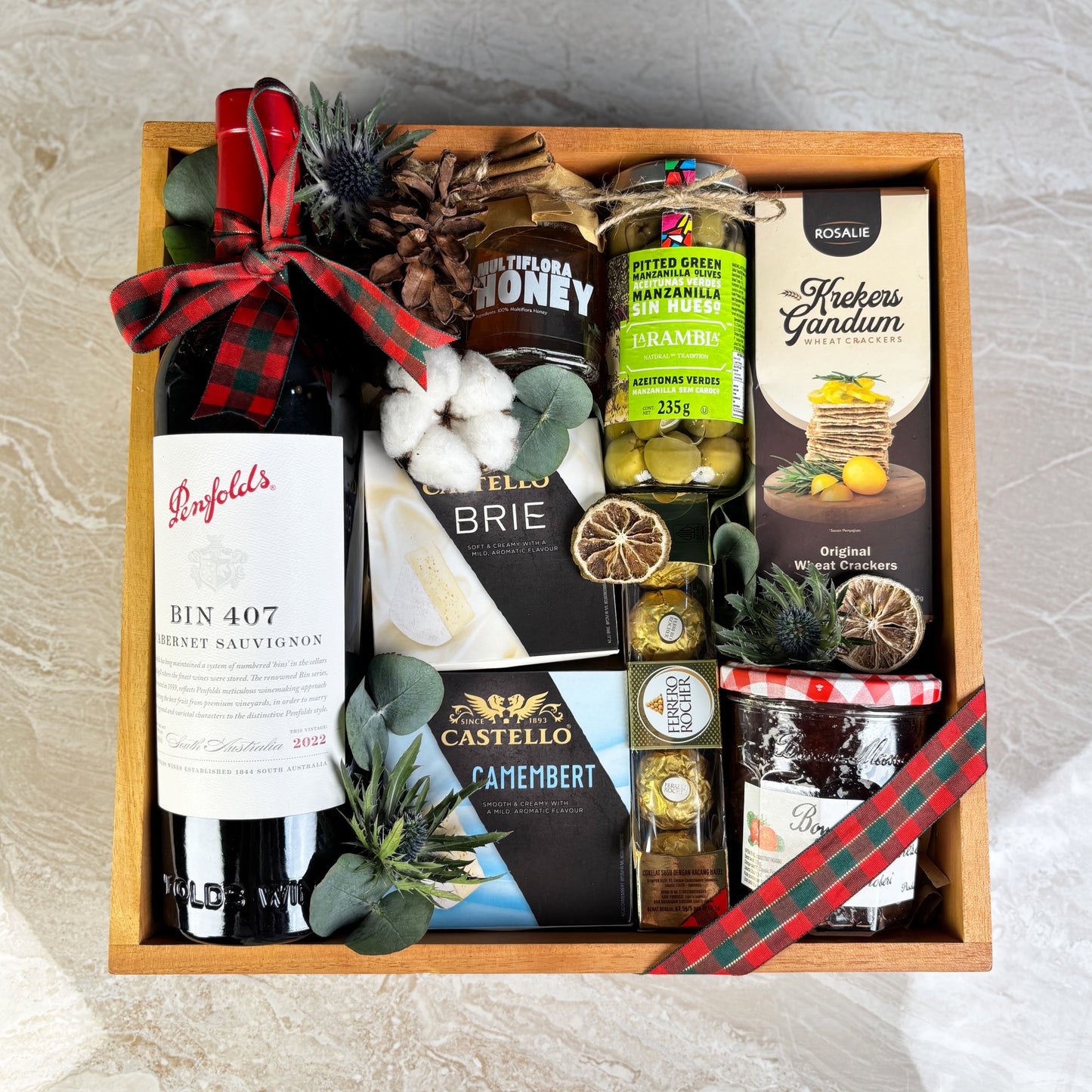wine hamper jakarta with Penfolds wine, cheese, and other snacks on a textured surface. Gourmet Hamper Jakarta, Gourmet Hamper Surabaya, Christmas Hamper Jakarta, hamper natal jakarta, surabaya