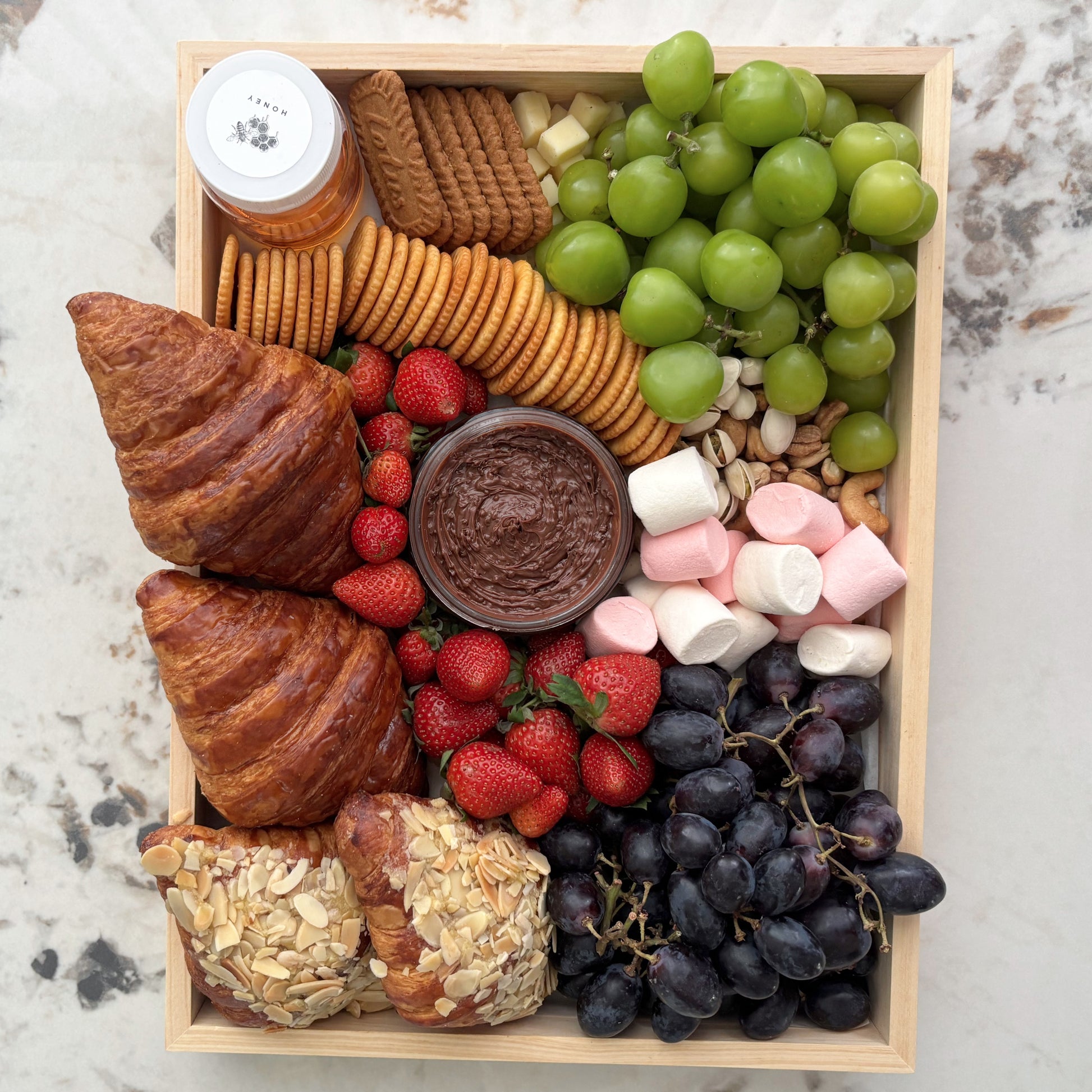 Assorted food platter with pastries, fruits, and snacks in a wooden box. best sweet platter jakarta and surabaya, by le bliss platter