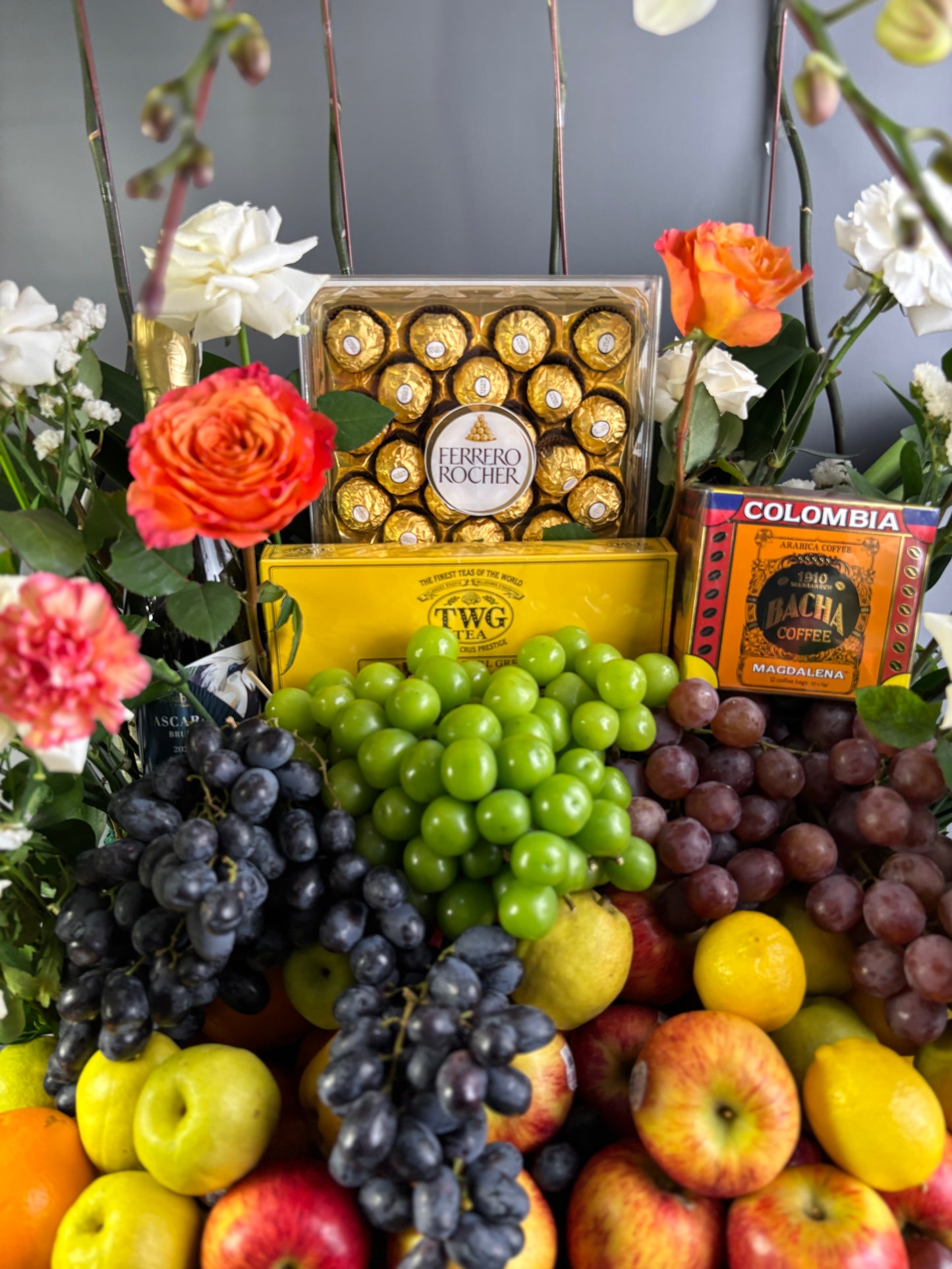Assorted fruits and flowers with a box of chocolates and tea packaging. fruit hamper luxury jakarta, surabaya, indonesia