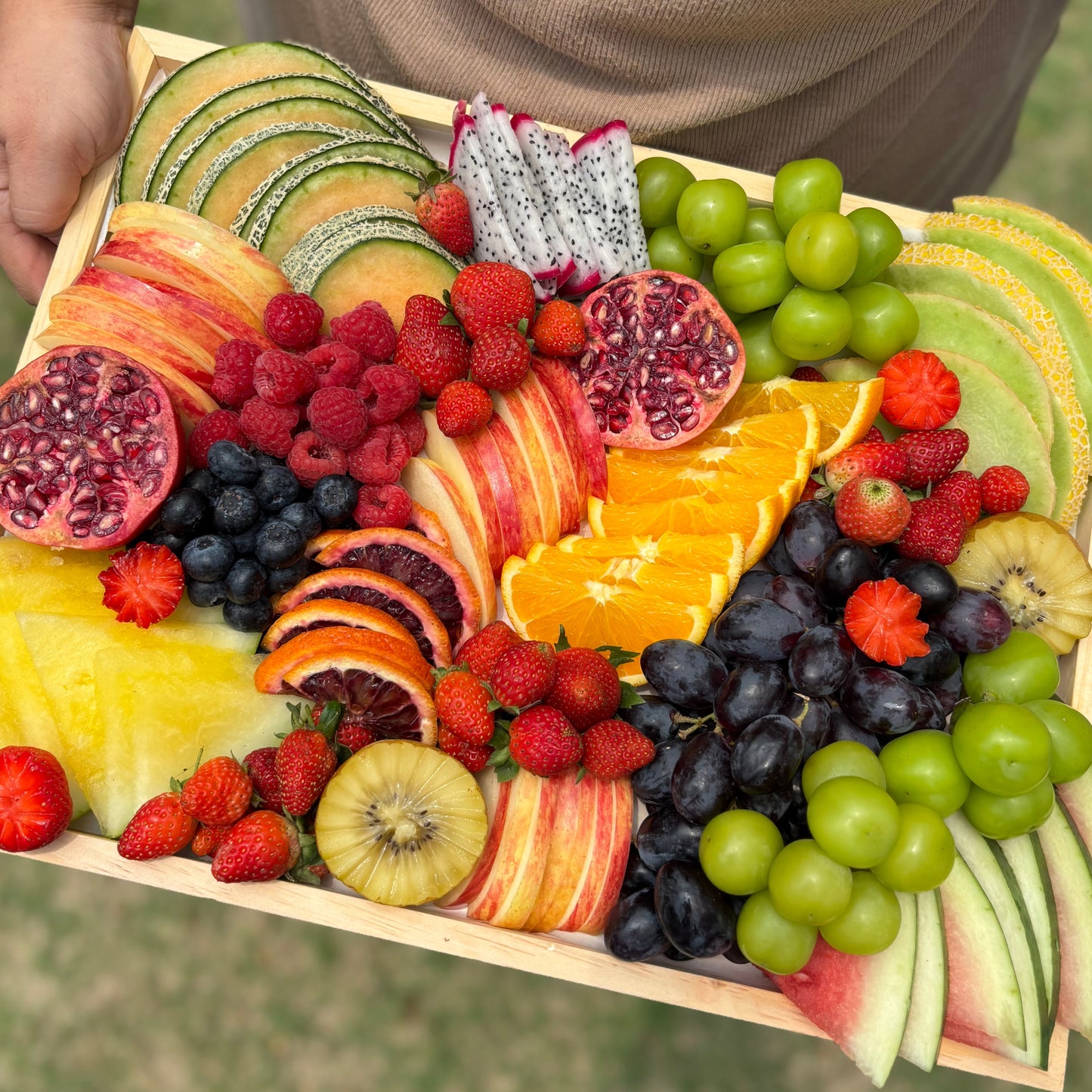 Assorted fruits including apples, oranges, grapes, and kiwis on a wooden tray. Colorful Fruit Platter | Luxury Fruit Platter Jakarta & Surabaya – Le Bliss Platter. best Fruit platter surabaya, best fruit platter jakarta 