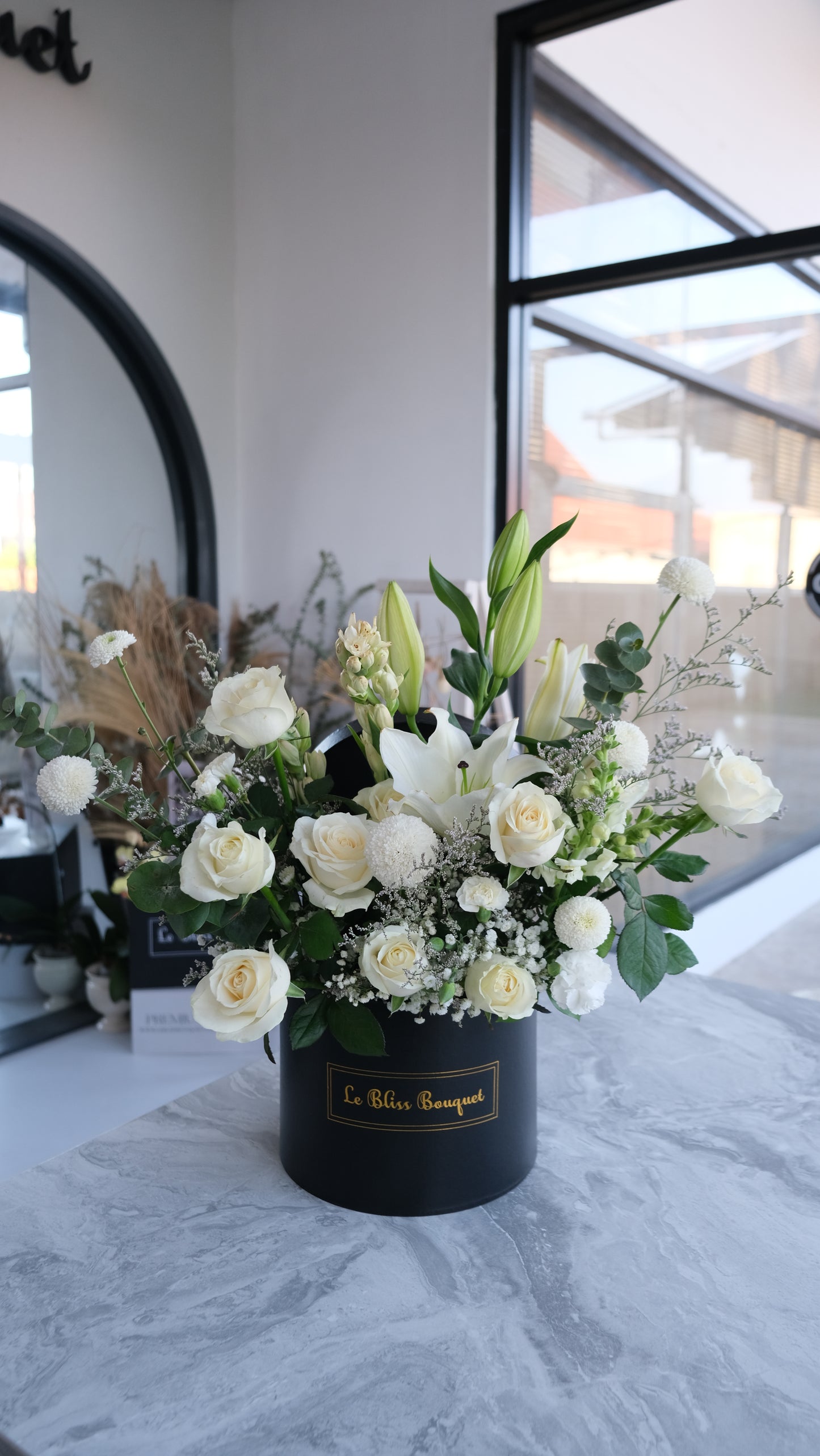 Bloombox elegan dengan lily putih dan mawar putih dari florist Surabaya, cocok untuk hadiah spesial dan pengiriman ke Cirebon & Jabodetabek. florist surabaya, toko bunga surabaya