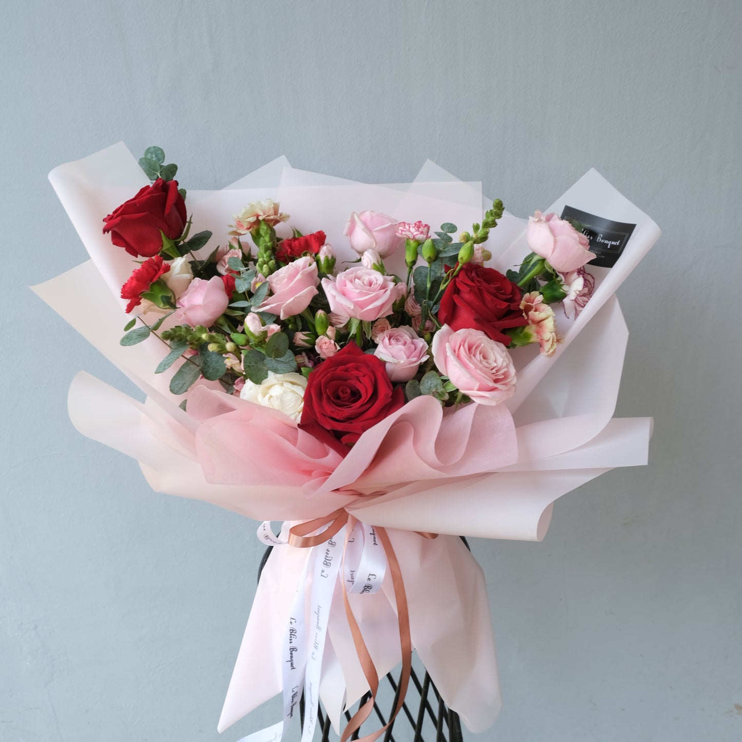 Bouquet of red and pink roses with greenery on a light gray background. Bouquet of flowers with pink and red roses on a light gray background. red explorer rose with soft pink rose. florist jakarta, florist surabaya, florist cirebon
