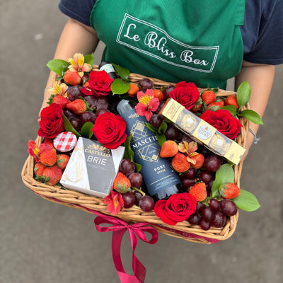 Elegant wine hamper with Sababay Mascetti red wine, Brie cheese, fresh grapes, strawberries, Ferrero Rocher chocolates, and a jam jar, beautifully arranged with fresh flower toppings. Luxury gift hamper for delivery in Jakarta, Bintaro, Tangeran