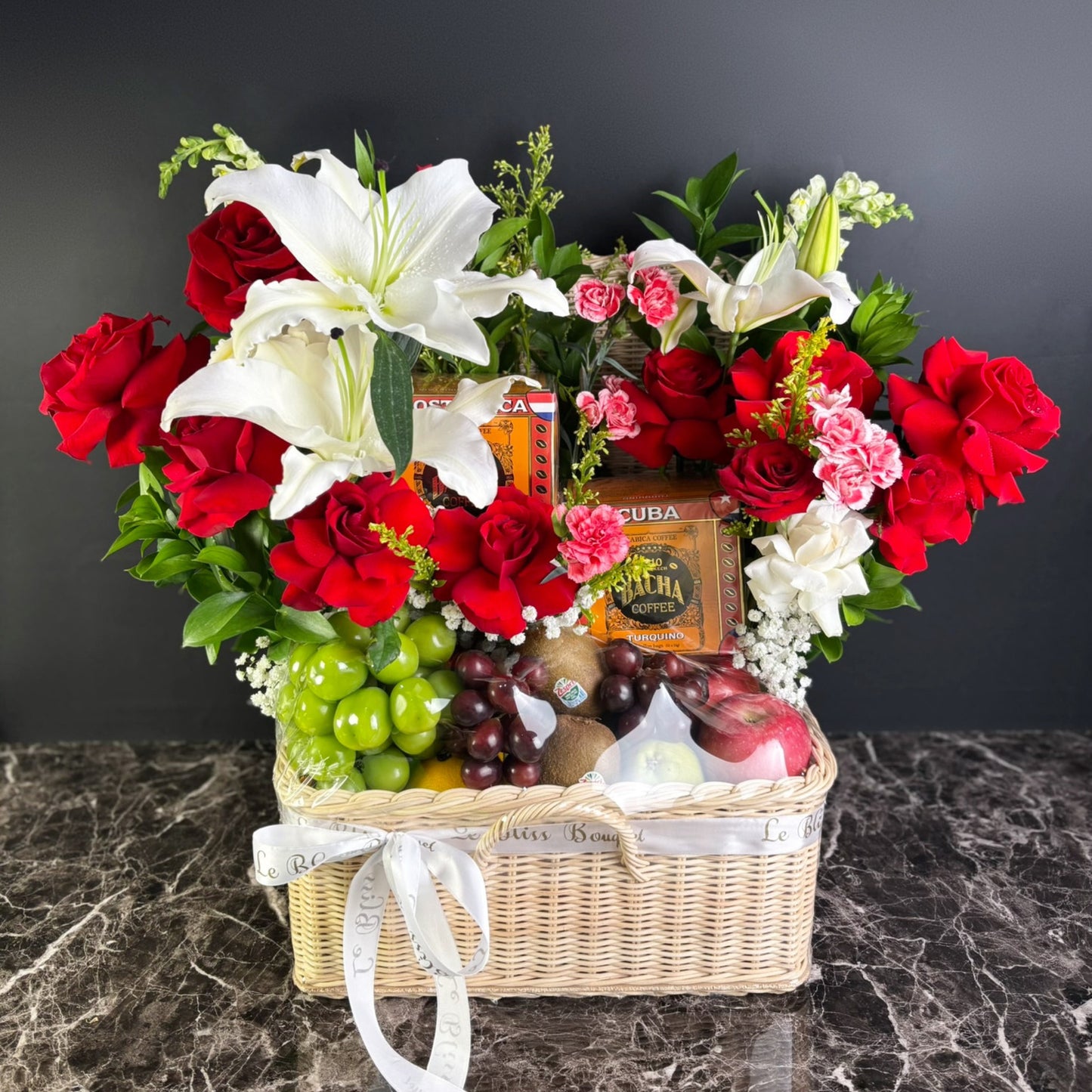Floral arrangement in a basket with fruits and a box of cigars on a dark surface, bacha coffee hamper surabaya, jakarta, tangerang. cirebon