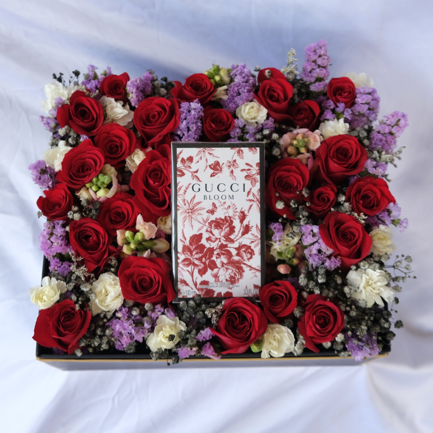 Floral arrangement with a Gucci Bloom box in the center on a white background. le bliss bouquet. Perfume hamper by le bliss. perfume hamper jakarta, surabaya, gucci hamper jakarta