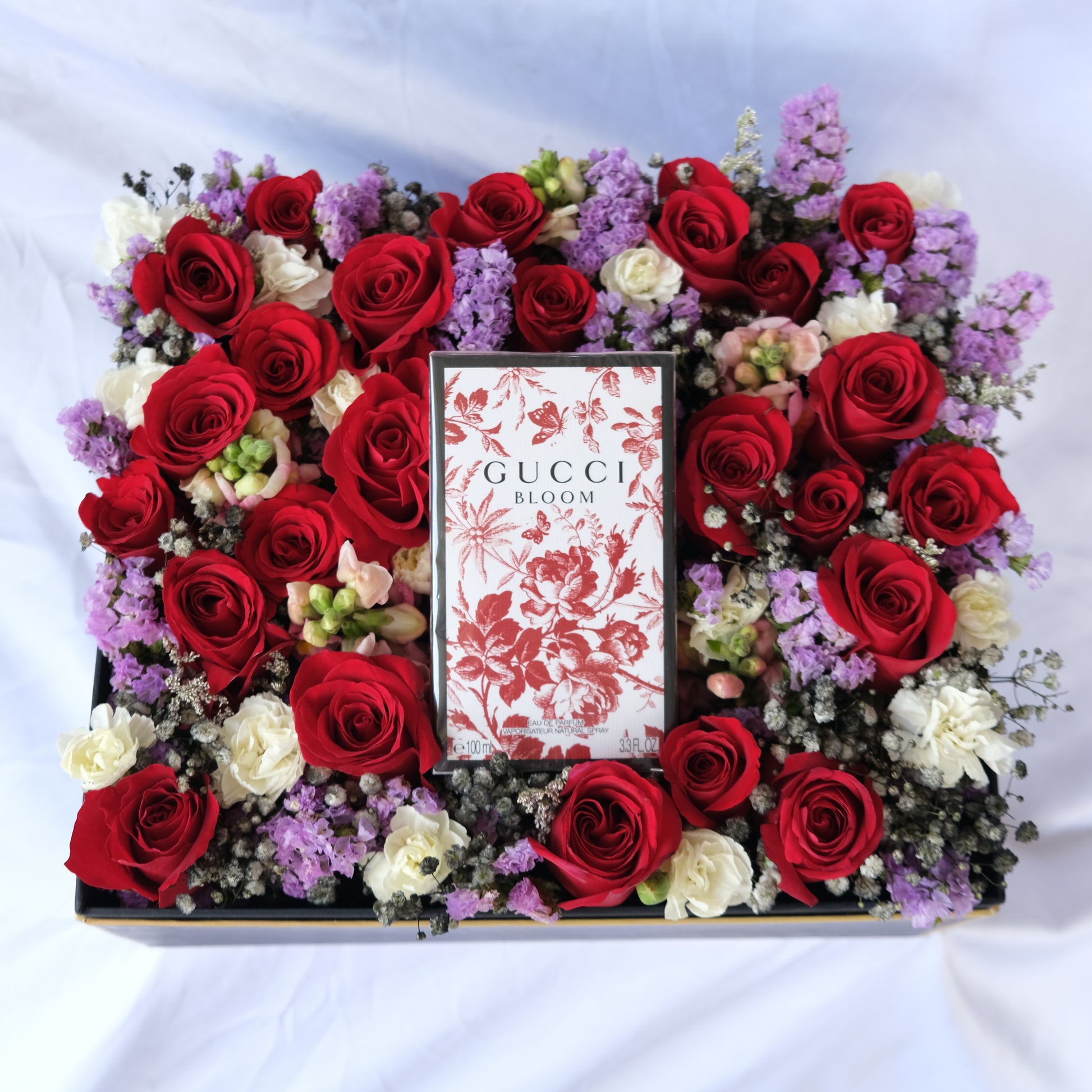 Floral arrangement with a Gucci Bloom box in the center on a white background. perfume hamper by le bliss. perfume hamper jakarta, surabaya, gucci hamper jakarta