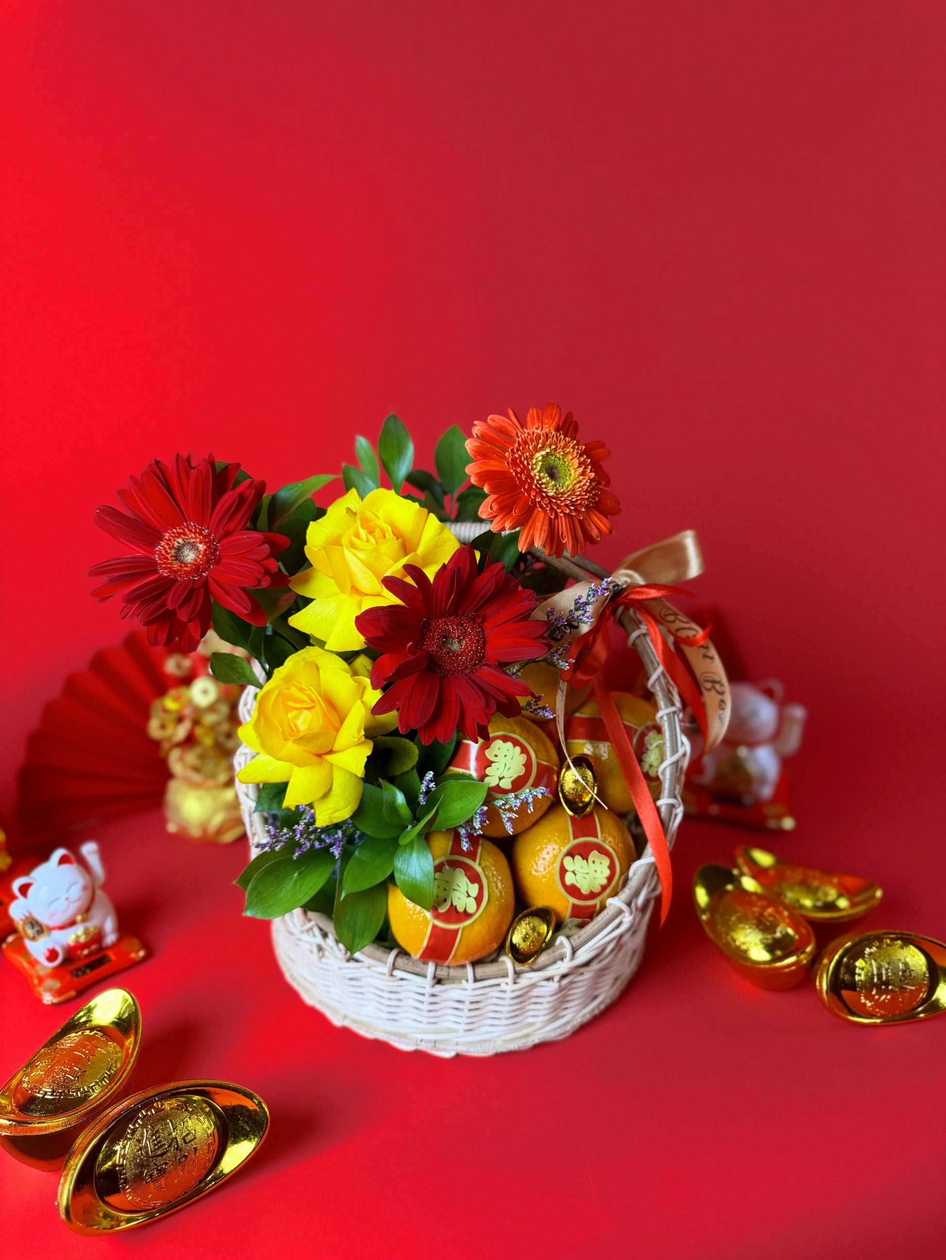 Floral arrangement with oranges and gold decorations on a red background. Imlek hamper buah segar dengan desain mewah cocok untuk hadiah Tahun Baru Cina