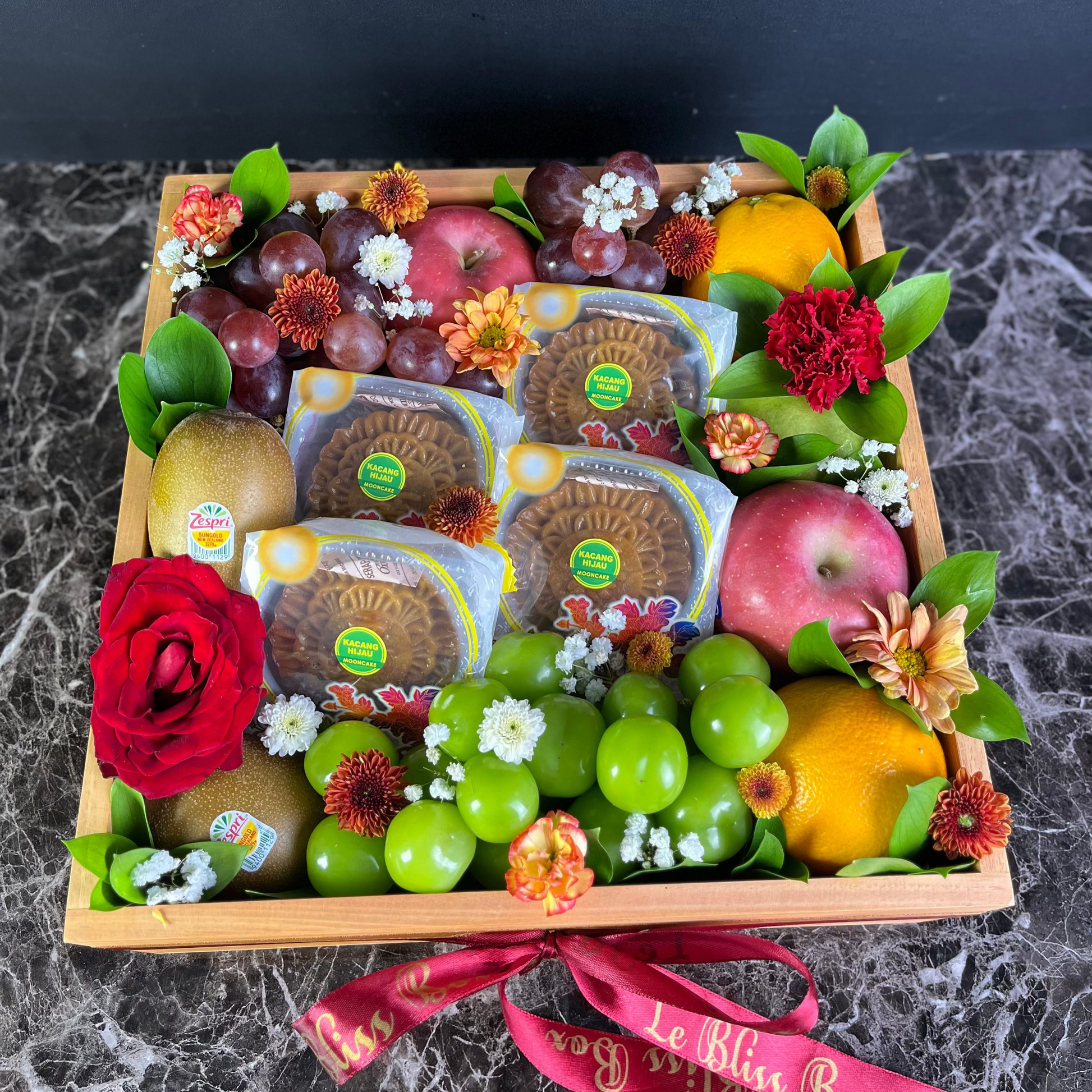 Fruit and cheese platter in a wooden box with decorative elements on a dark surface. mooncake mid autumn festival hamper jakarta, bintaro, tangerang, surabaya