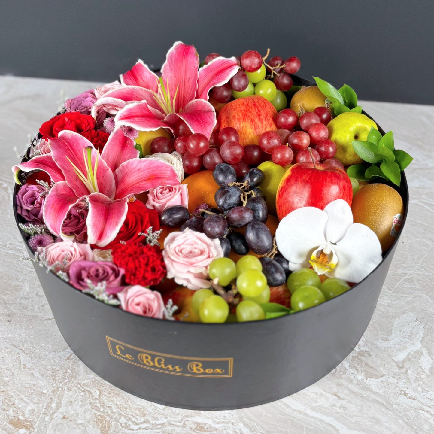 Fruit and flower arrangement for Mother's day gift in a black box with 'La Bliss Box' branding.  Blushing Grand Round Fruit Box | Luxury Fruit Hamper Jakarta, Surabaya. Kado Hari Ibu
