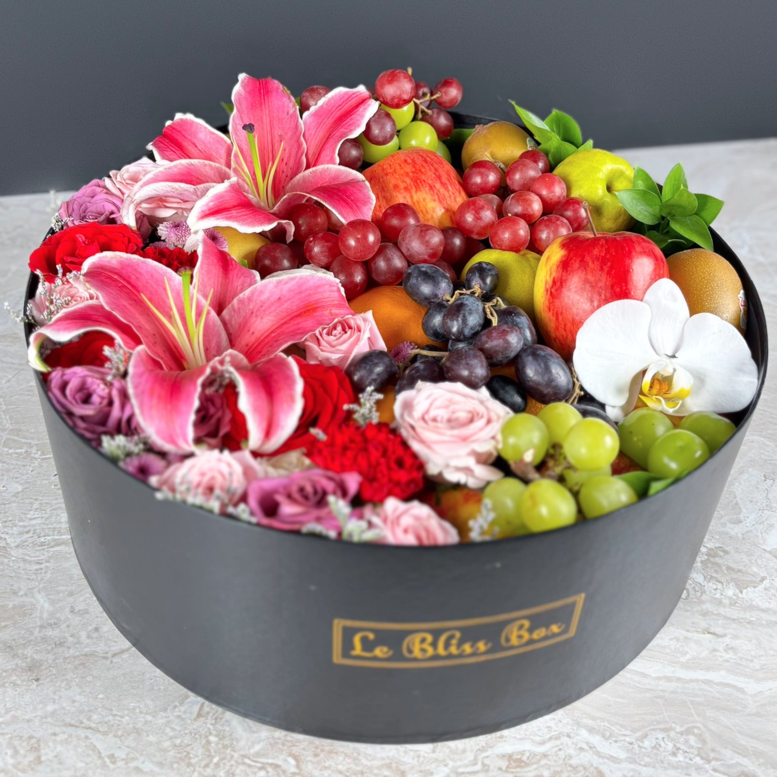 Fruit and flower arrangement for Mother's day gift in a black box with 'La Bliss Box' branding.  Blushing Grand Round Fruit Box | Luxury Fruit Hamper Jakarta, Surabaya. Kado Hari Ibu Jakarta