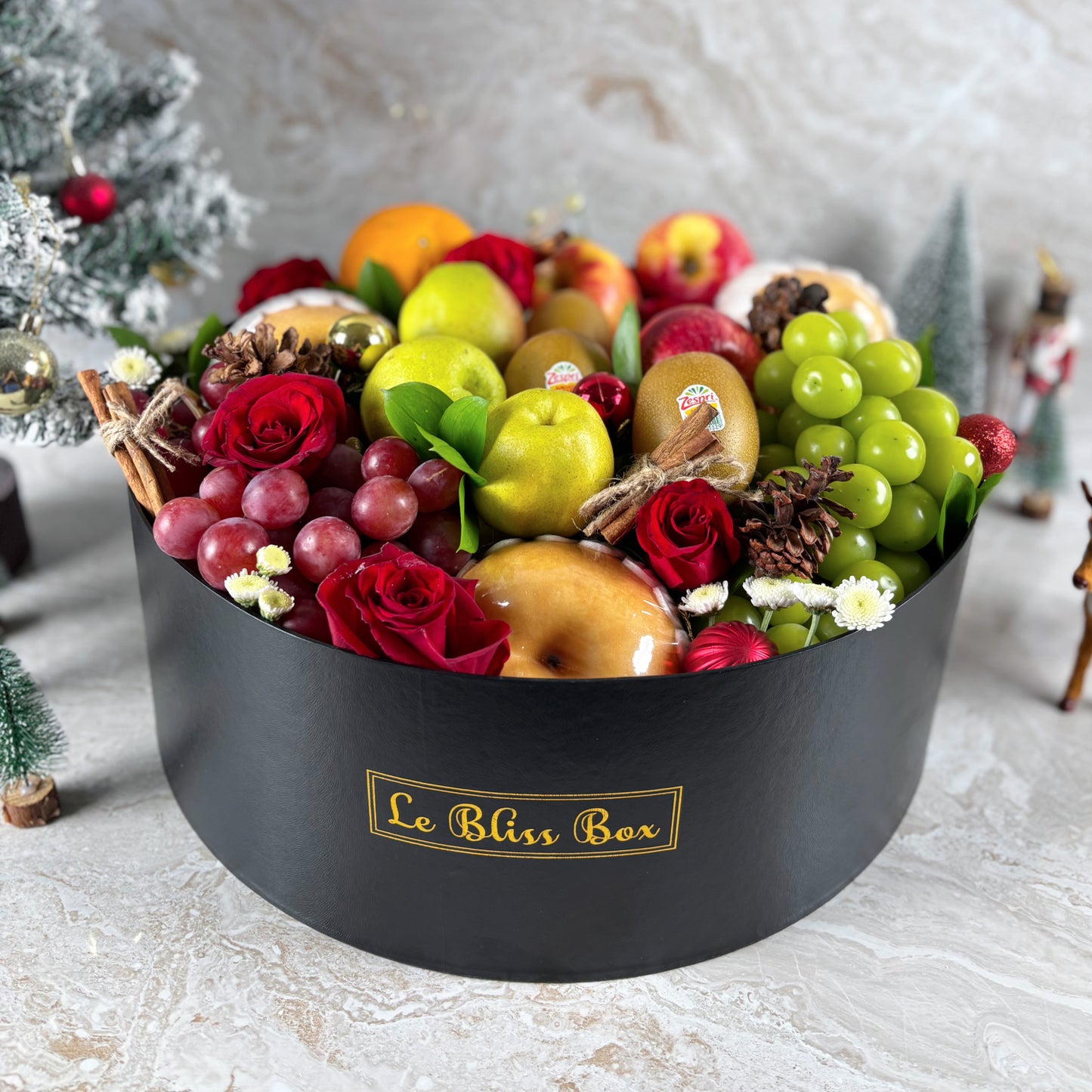 Fruit and flower arrangement in a black box labeled 'Le Bliss Box' on a light background. parcel buah natal, christmas hamper surabaya, christmas hamper jakarta