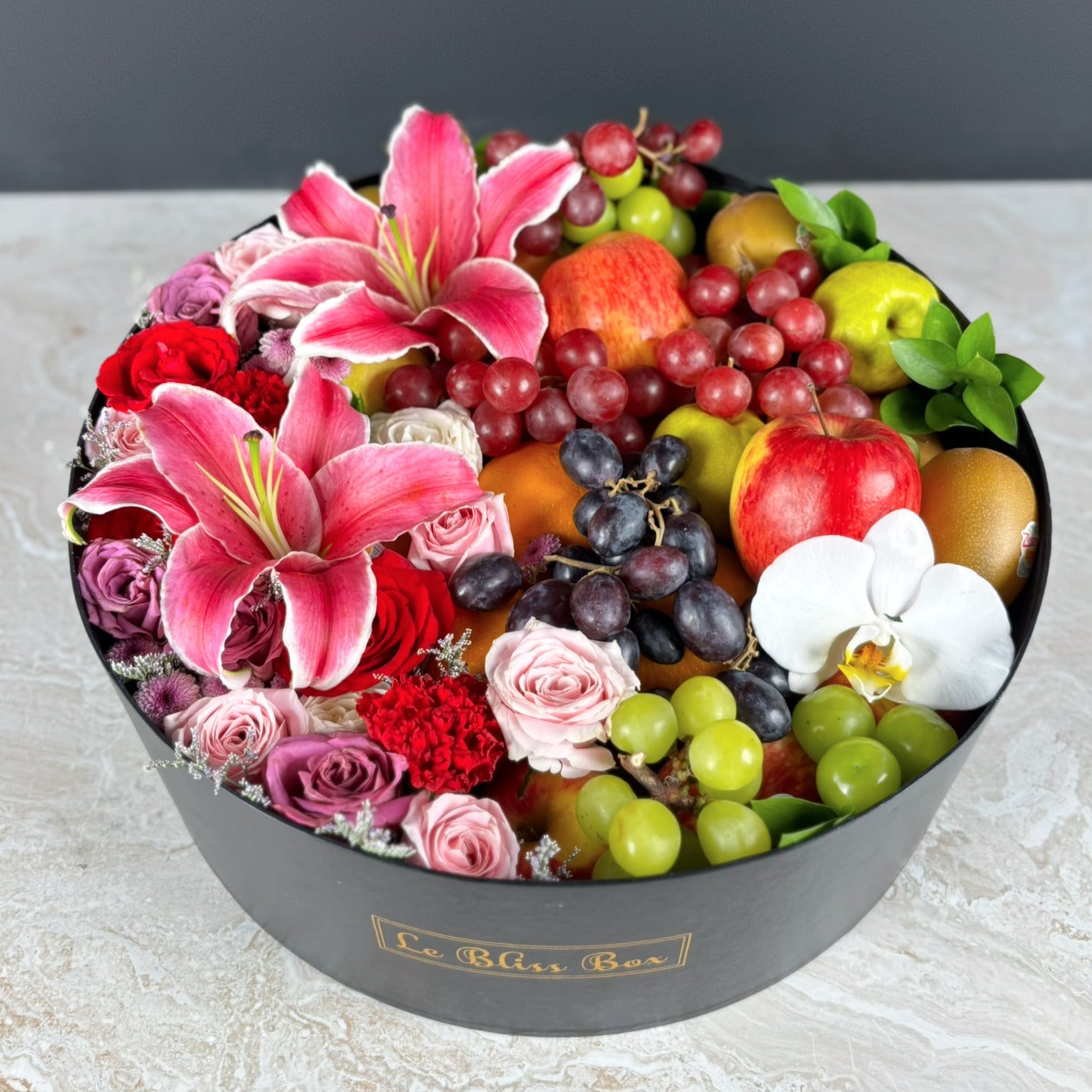 Fruit and flower arrangement in a black box with 'La Bliss Box' branding.  Blushing Grand Round Fruit Box | Luxury Fruit Hamper Jakarta, Surabaya 