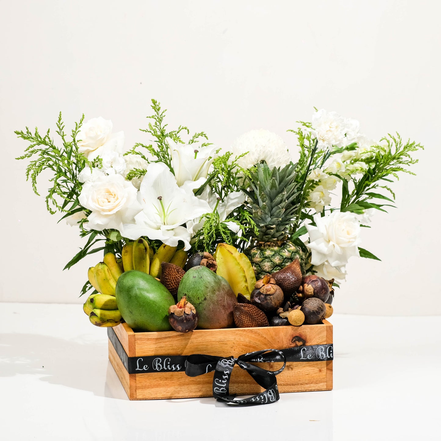 Fruit and flower arrangement in a wooden crate on a white background. parcel buah tropical surabaya, parcel buah cirebon, parcel buah jakarta, parcel buah terbaik