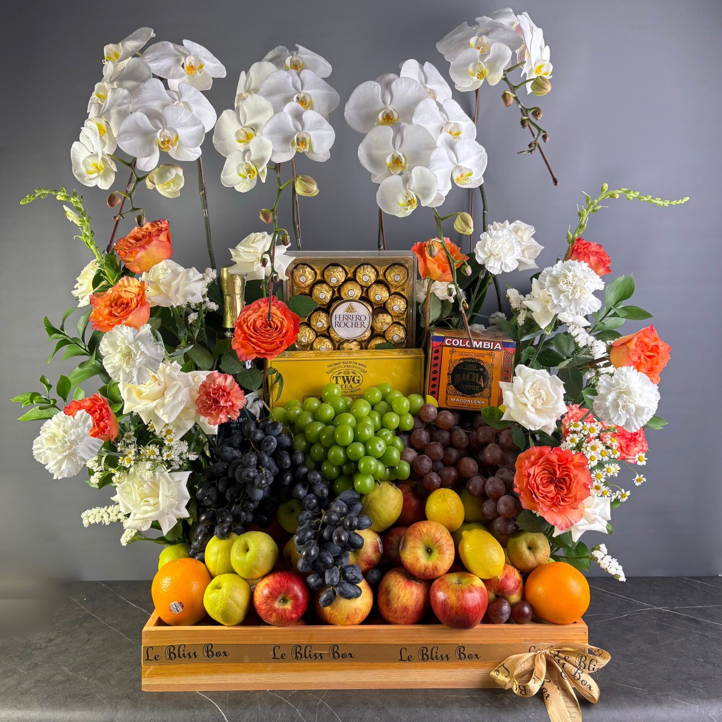 Fruit and flower arrangement with chocolates on a gray background. Wine Hamper Jakarta, Fruit & Flower hamper jakarta, surabaya, tangerang