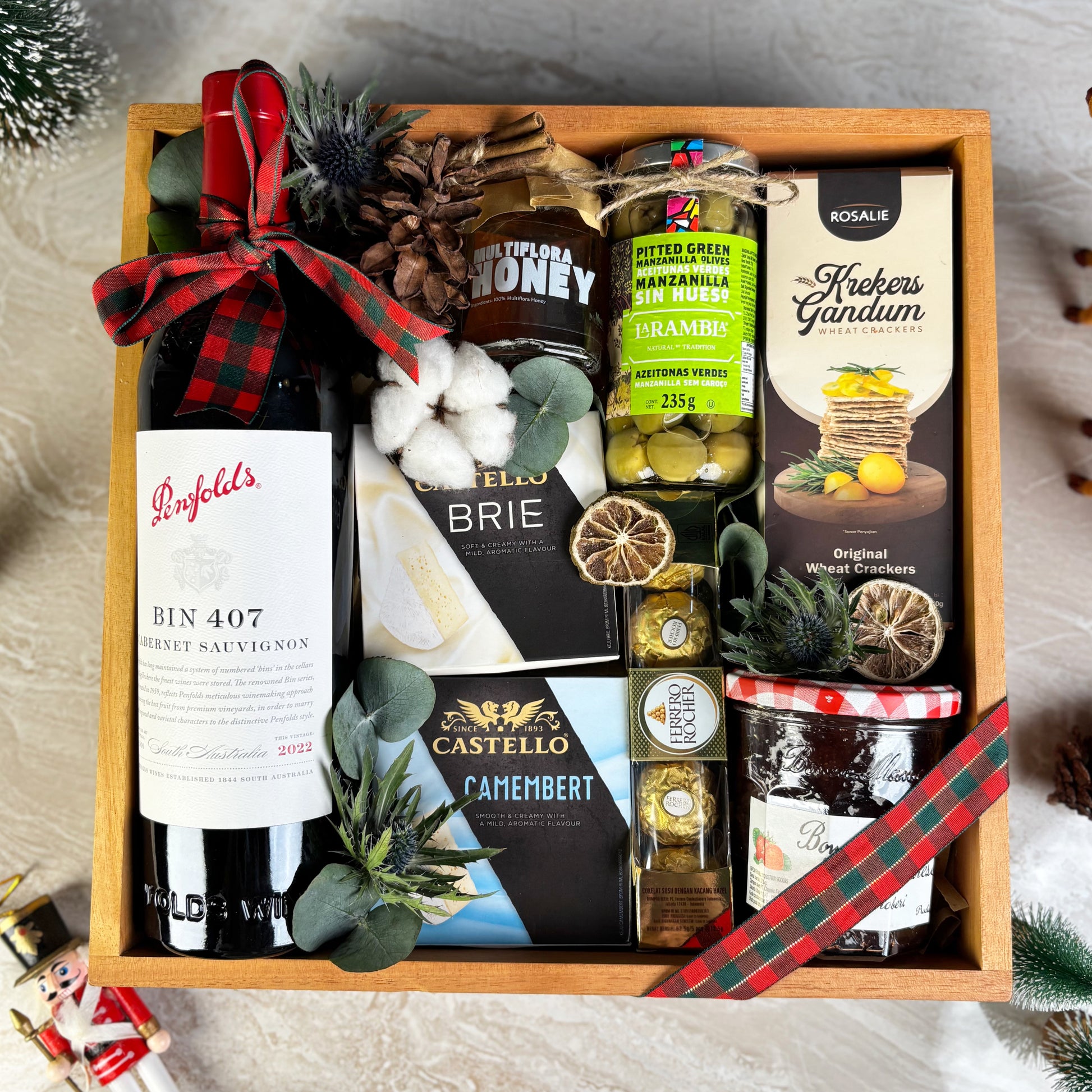 Gift basket with Penfolds wine, cheese, and other snacks on a textured surface. Gourmet Hamper Jakarta, Gourmet Hamper Surabaya, Christmas Hamper Jakarta, hamper natal jakarta, surabaya