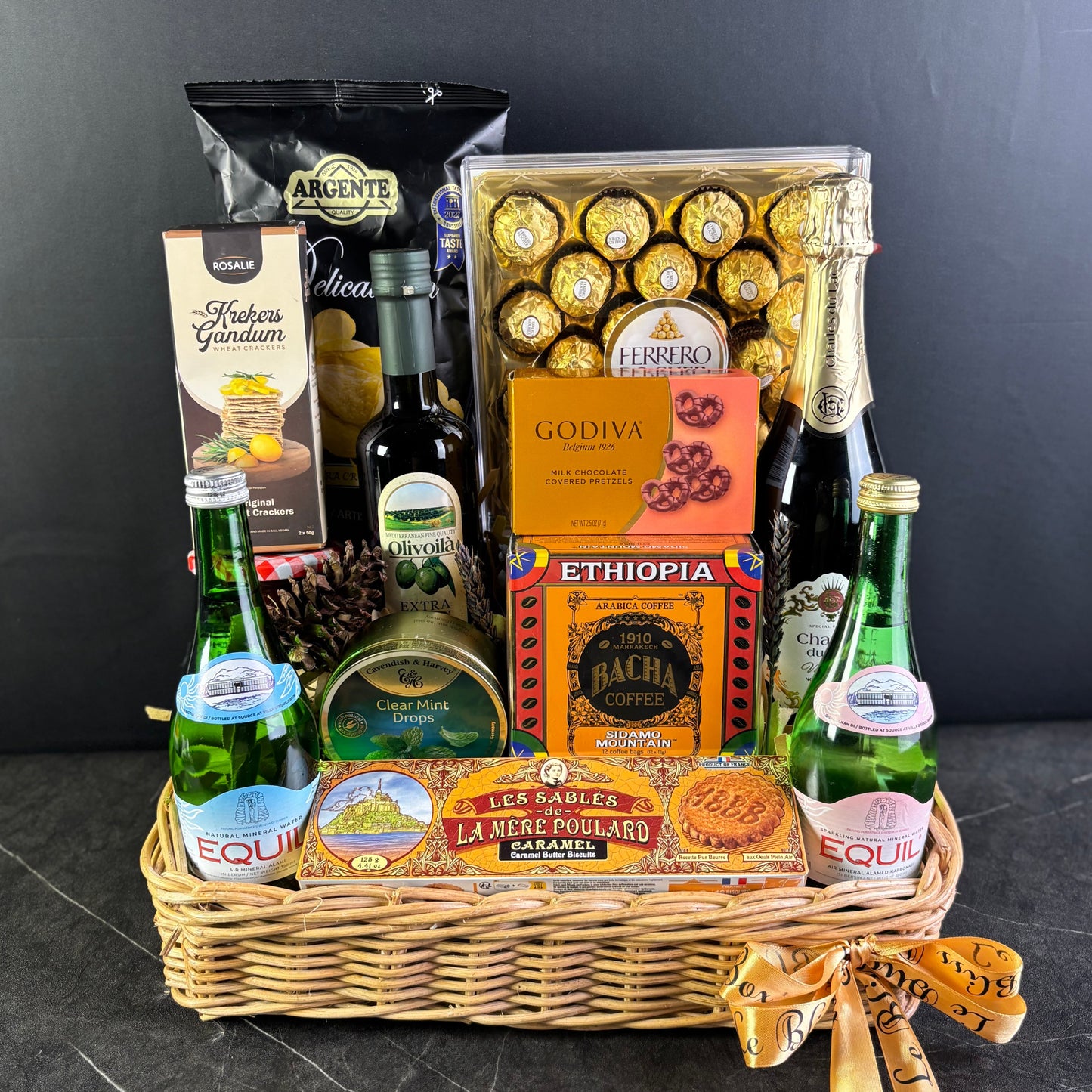 Gift basket with snacks, drinks, and chocolates on a dark surface. hamper jakarta, hamper surabaya, gourmet hamper jakarta