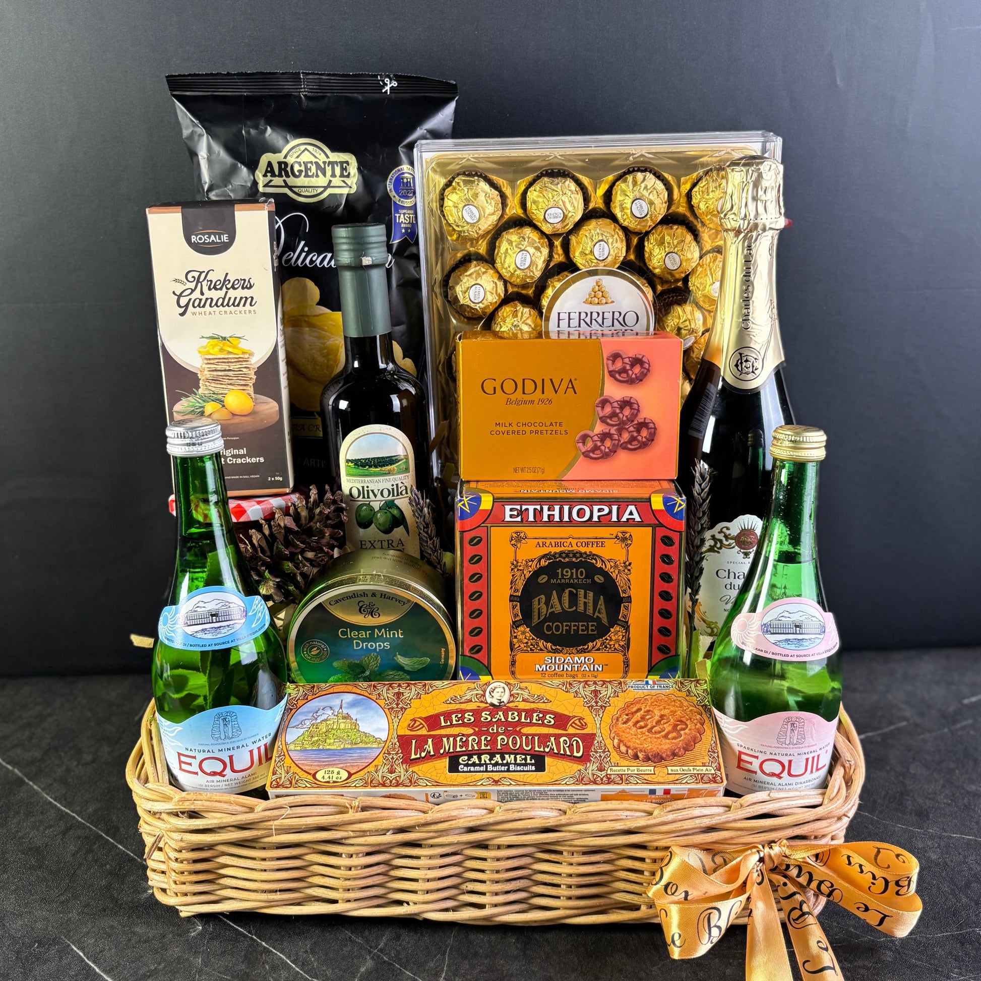 Gift basket with snacks, drinks, and chocolates on a dark surface. hamper jakarta, hamper surabaya, gourmet hamper jakarta