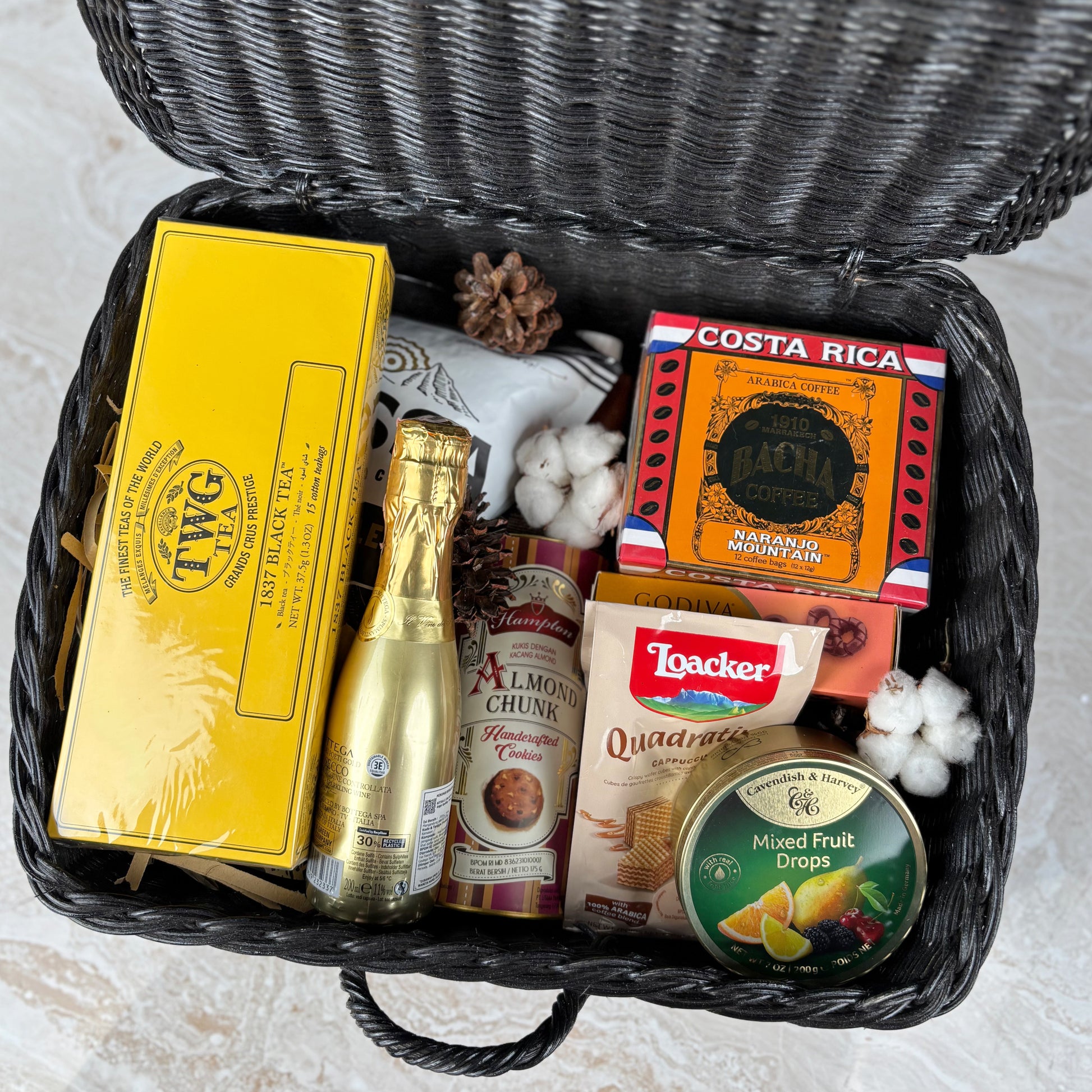 Gift basket with various items including a bottle, boxes, and snacks by le bliss box. a premium snack gourmet hamper in jakarta, surabaya, cirebon