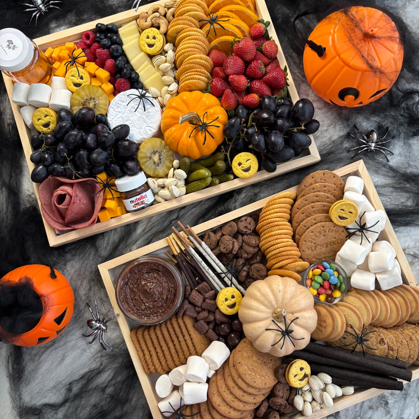 Halloween-themed charcuterie board with various treats and decorations on a dark surface. halloween platter jakarta, halloween platter surabaya