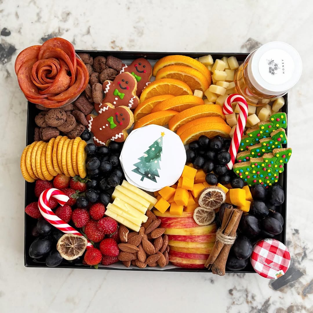 Holiday-themed charcuterie board with fruits, cheese, and cookies on a marble surface. Celebrate the holidays with Le Bliss Platter’s Christmas Cheese Platter — elegant gourmet selection. Festive platter delivery in Jakarta & Surabaya.