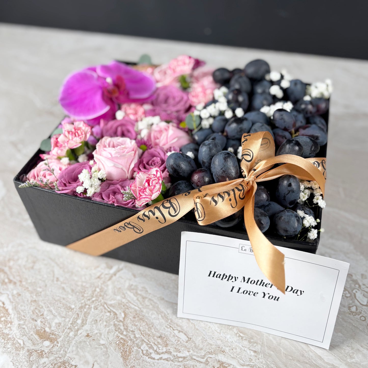 Pink Lilac Sonata Autumn Grape Box dari Le Bliss Bouquet. Kado Hari Ibu elegan dengan bunga & buah premium. Pengiriman Surabaya, Jakarta & Cirebon. Soft, sweet & luxurious. Kado Anggur