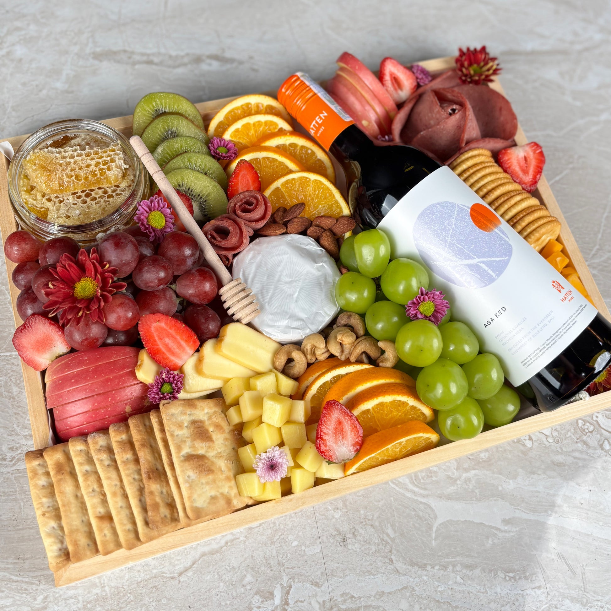Red wine cheese platter on wooden tray with fruits and cheeses by le bliss platter. Luxury cheese platter gift with wine, grapes, and brie