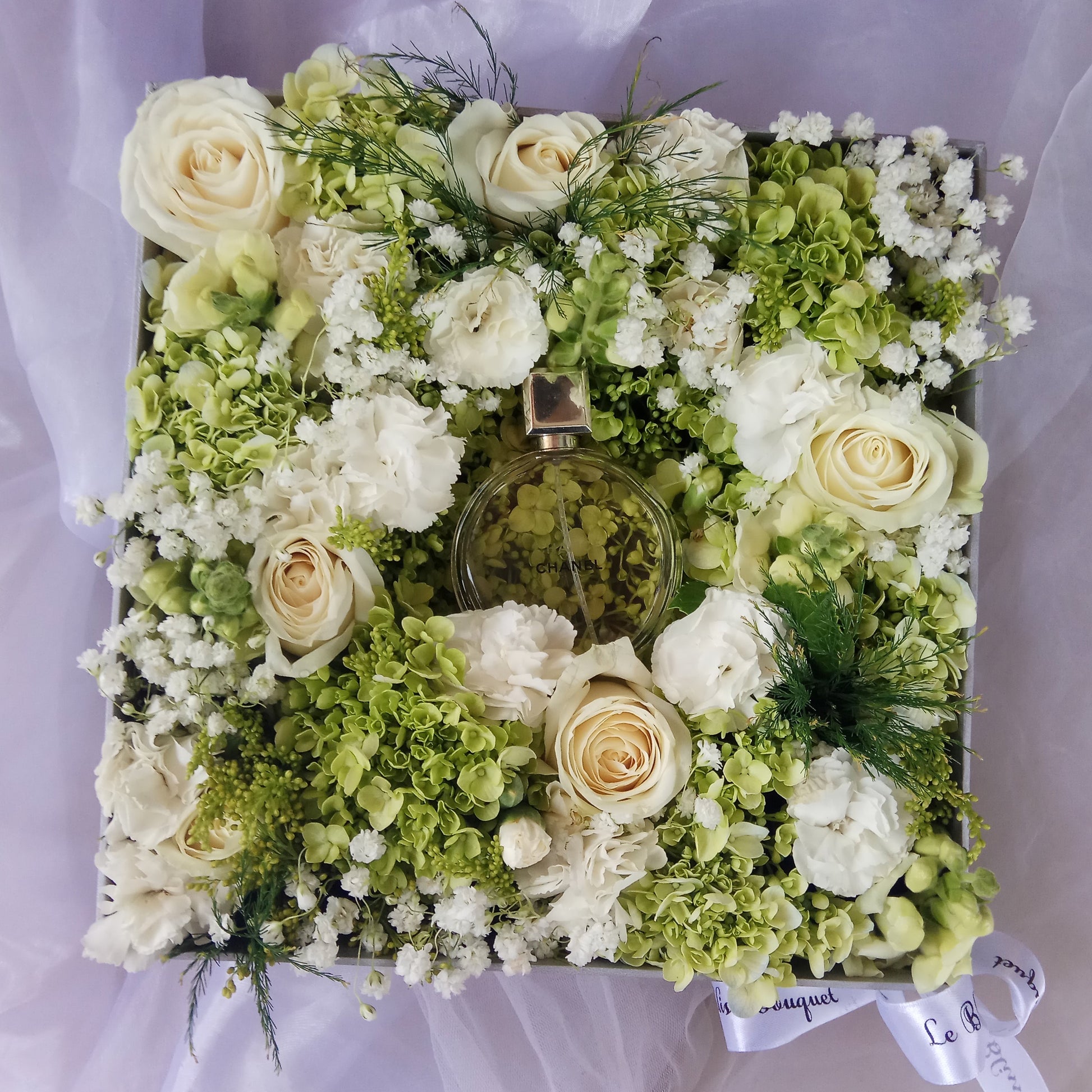 Square flower arrangement with green and white flowers on a light purple background. chanel chance perfume hamper flower indonesia, jakarta. florist jakarta, florist bintaro, florist surabaya