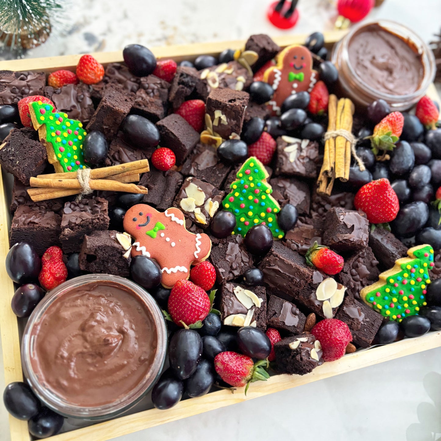 brownie platter with berries, cookies, and dips on a wooden board with Christmas decorations. Xtra Christmas Brownies Platter | Christmas Platter Jakarta & Surabaya – Le Bliss Platter