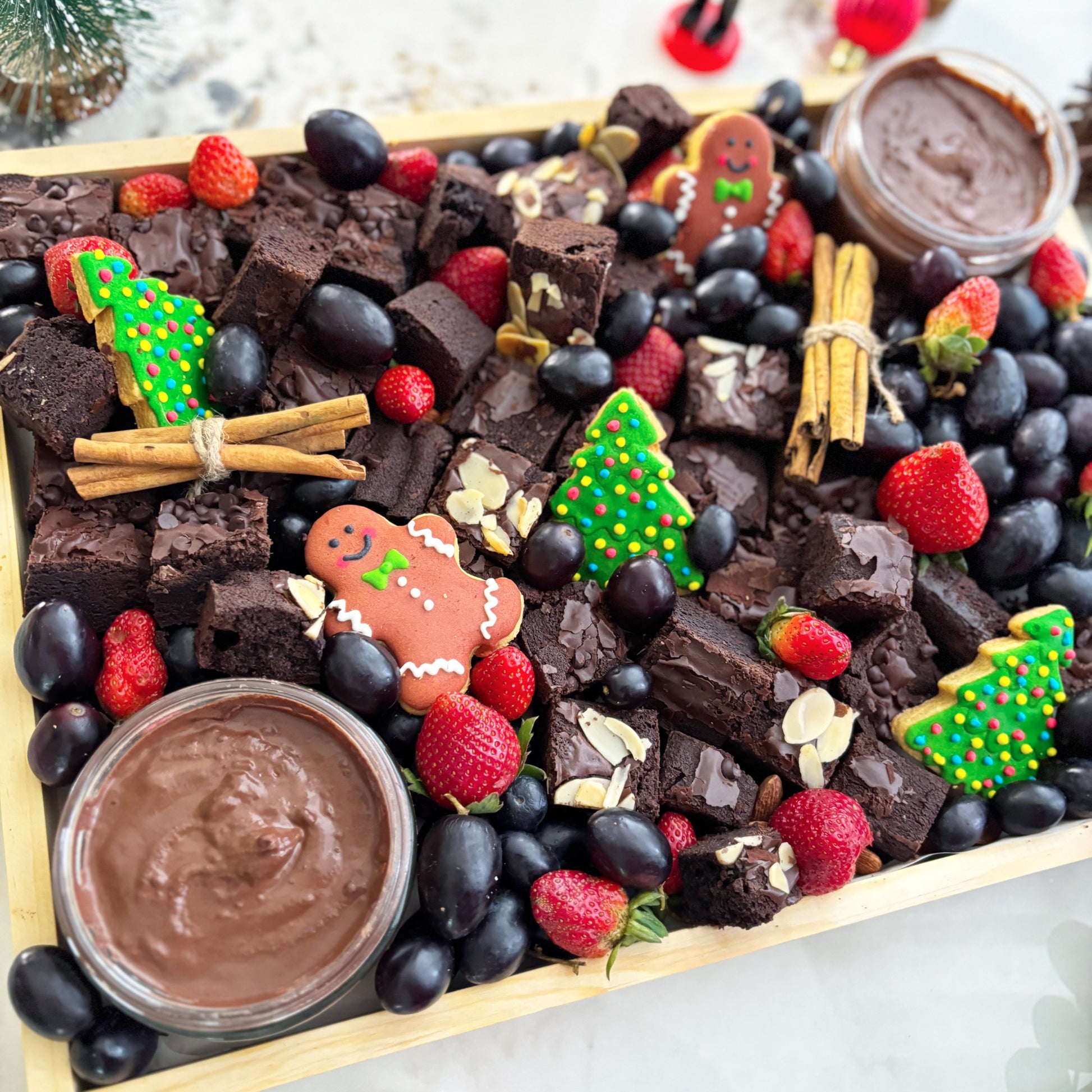brownie platter with berries, cookies, and dips on a wooden board with Christmas decorations. Xtra Christmas Brownies Platter | Christmas Platter Jakarta & Surabaya – Le Bliss Platter