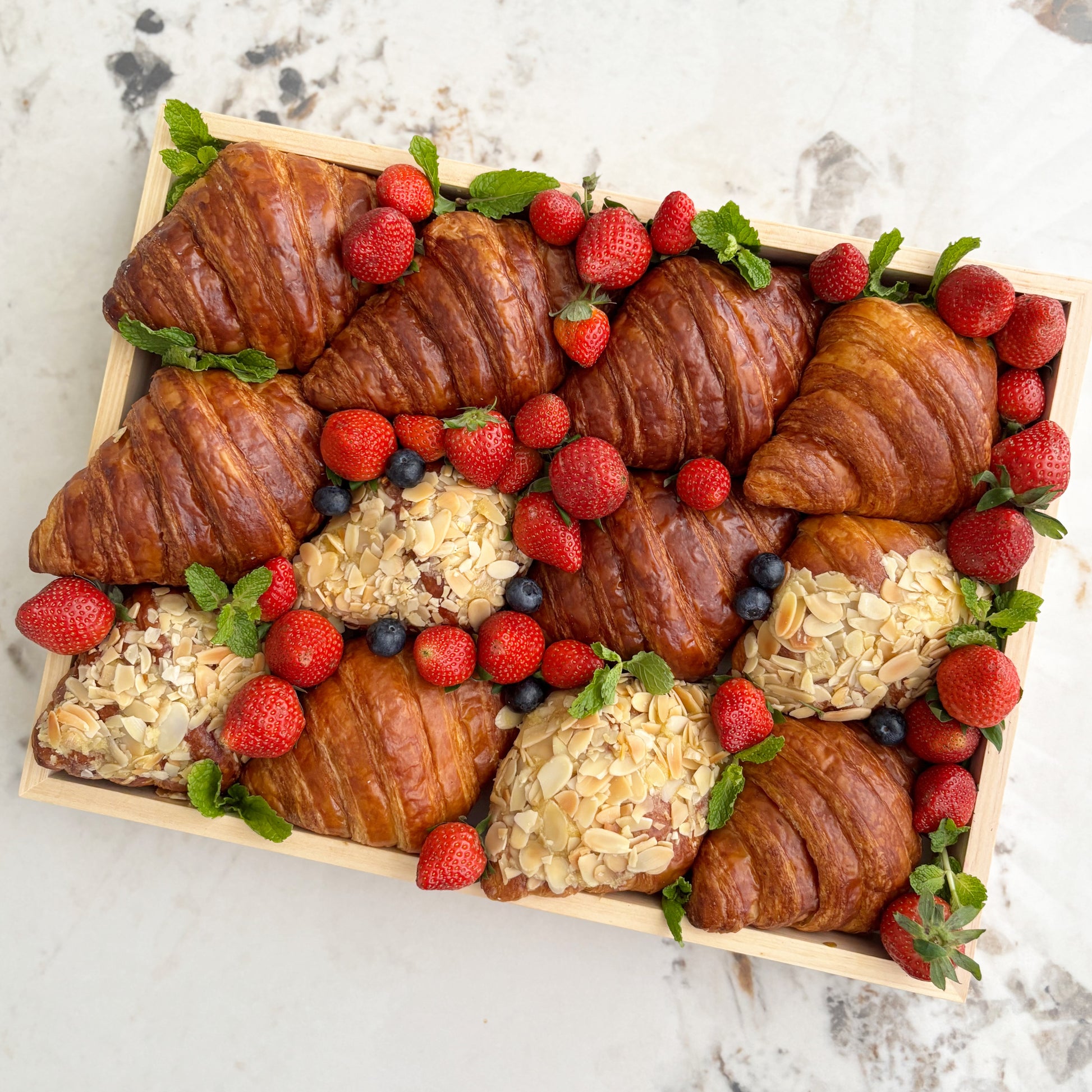 croissants and pastries with berries on a marble surface. best platter in jakarta, best platter in surabaya by le bliss platter