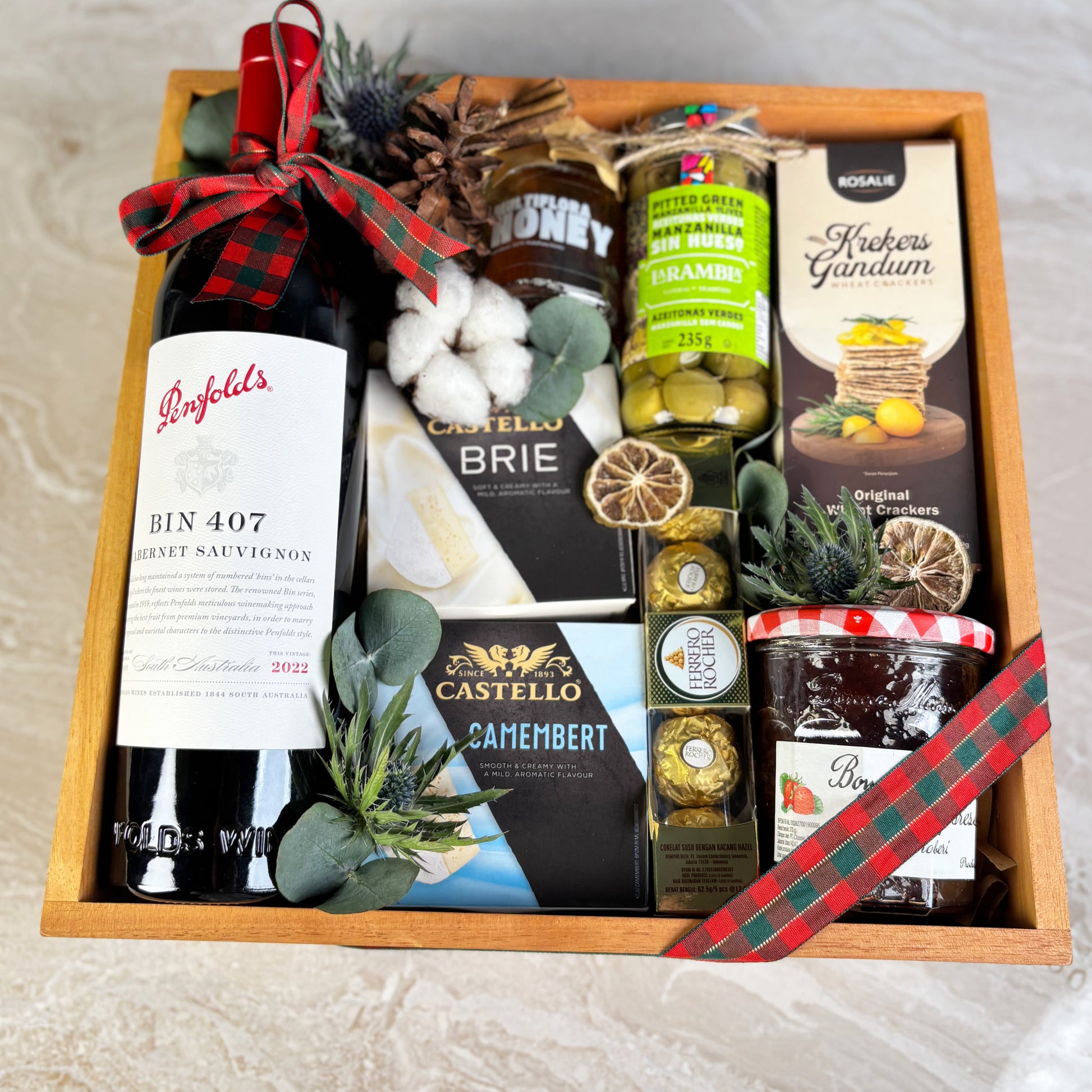 gift hamper with Penfolds wine, cheese, and other snacks on a textured surface. Gourmet Hamper Jakarta, Gourmet Hamper Surabaya, Christmas Hamper Jakarta, hamper natal jakarta, surabaya