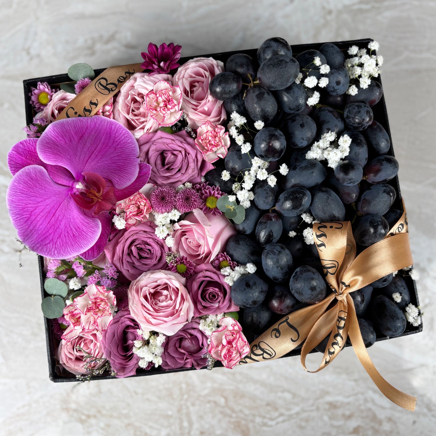 Pink Lilac Sonata Autumn Grape Box dari Le Bliss Bouquet. Kado Hari Ibu elegan dengan bunga & buah premium. Pengiriman Surabaya, Jakarta & Cirebon. Soft, sweet & luxurious.