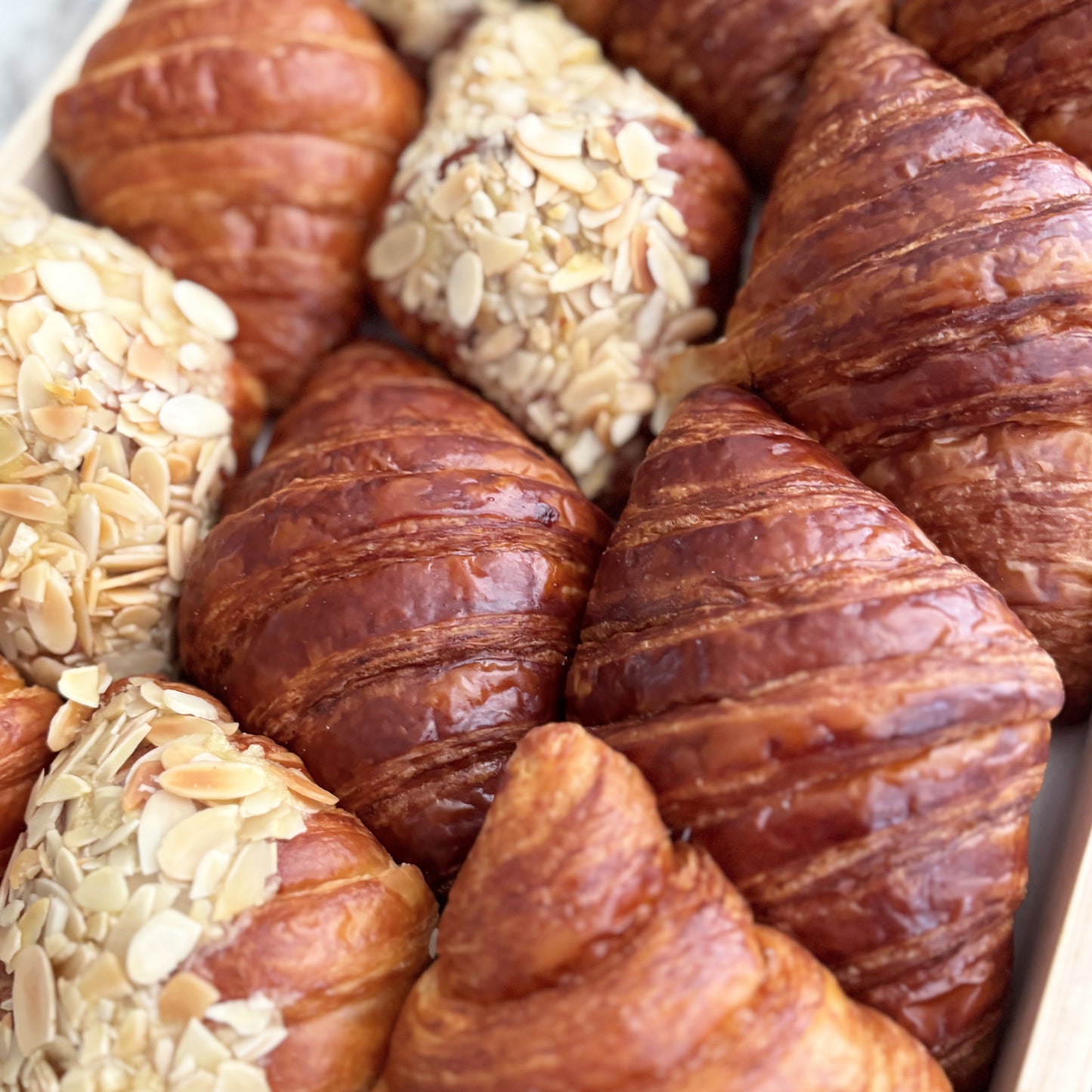 Assorted croissants with different fillings on a wooden board by le bliss platter