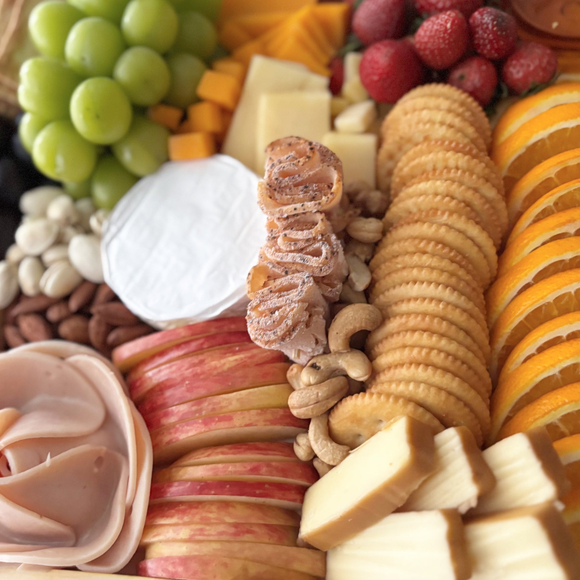Assorted fruits, cheeses, and crackers on a platter