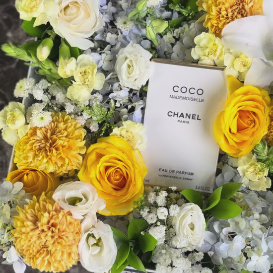 Floral arrangement with a Chanel perfume bottle at the center on a marble surface. Perfume hamper jakarta, surabaya by le bliss bouquet