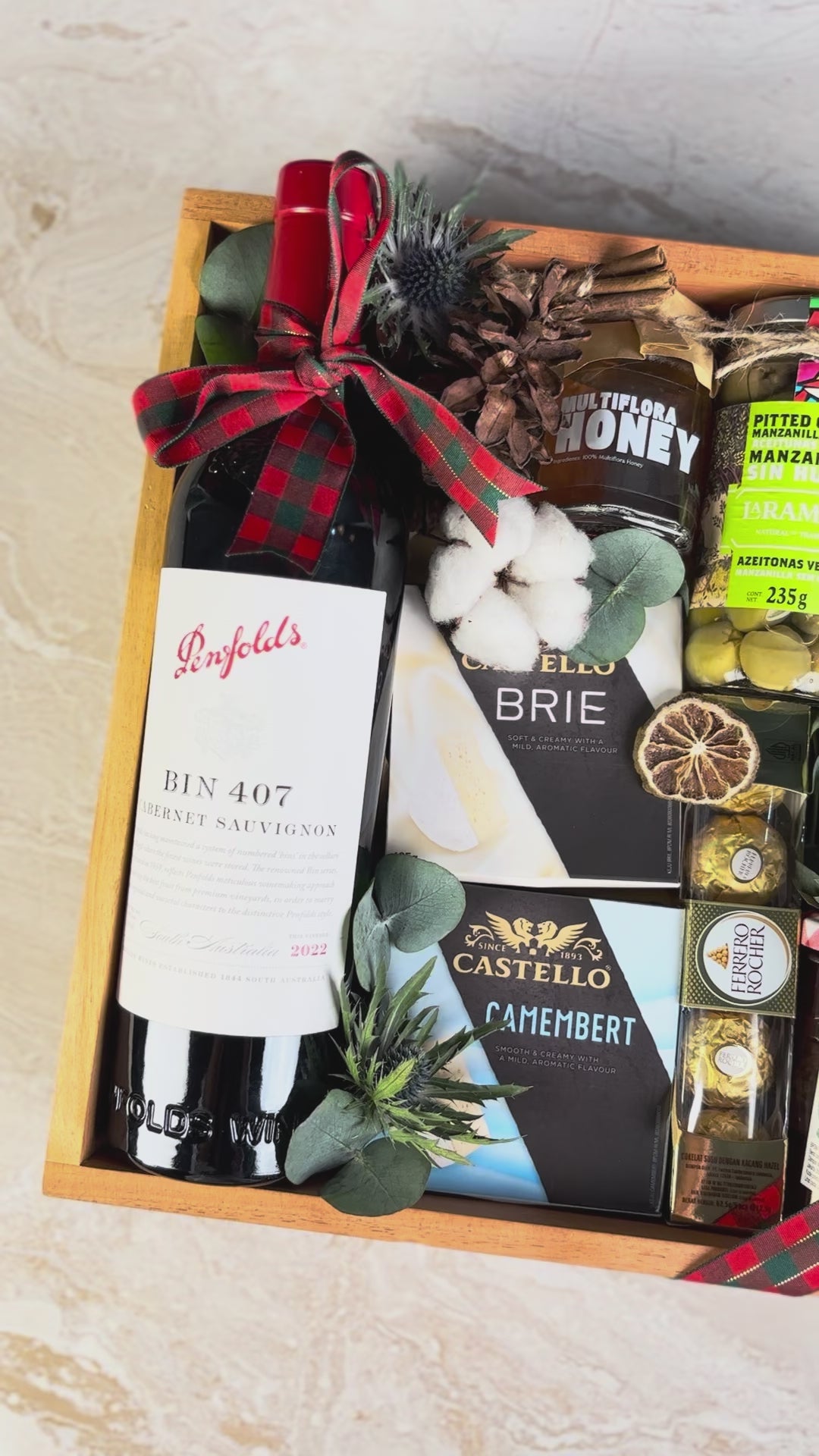 Gift basket with Penfolds wine, cheese, and other snacks on a textured surface. Gourmet Hamper Jakarta, Gourmet Hamper Surabaya, Christmas Hamper Jakarta, hamper natal jakarta, surabaya