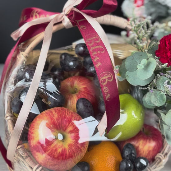 Fruit basket with flowers and a red ribbon on a festive background. Christmas Blossom Fruit Parcel | Best Christmas Hamper Jakarta, Tangerang, Cirebon & Surabaya – Le Bliss Bouquet