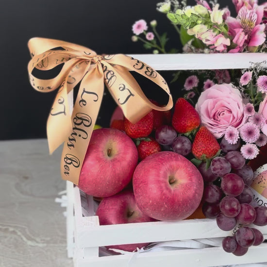 parcel buah dengan bunga dan wine. Gift basket with fruits, flowers, and a bottle of wine on a dark background. sababay wine hamper surabaya, jakarta, tangerang. fruit hamper with wine