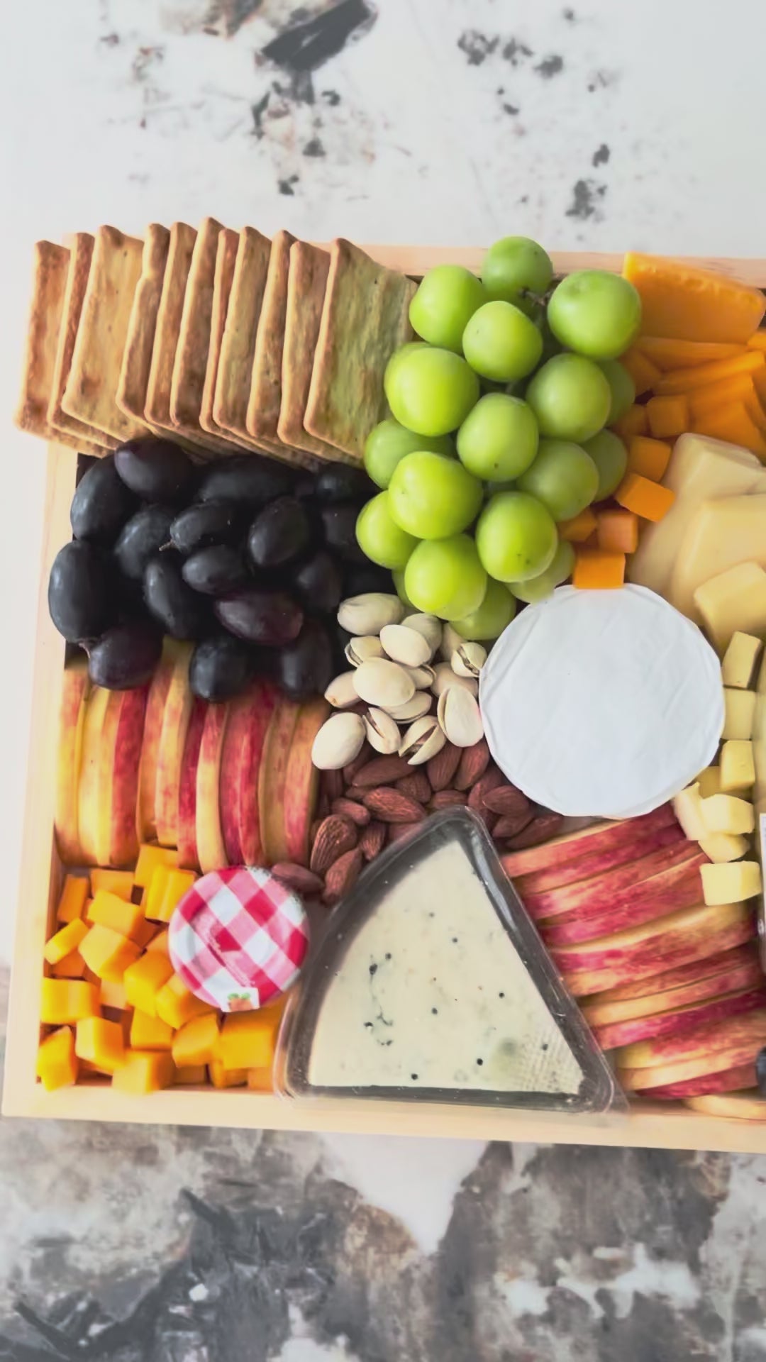 Assorted fruits, cheeses, and crackers on a wooden board with a bottle of champagne. Bottega Wine Cheese Platter | Best Wine & Cheese Platter in Jakarta & Surabaya – Le Bliss Platter